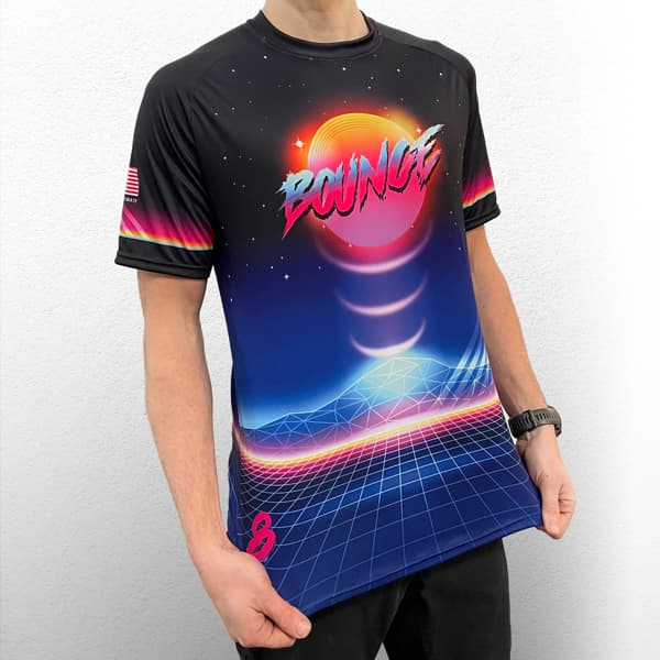 torso of man wearing a dark blue and pink raglan jersey with bounce writing