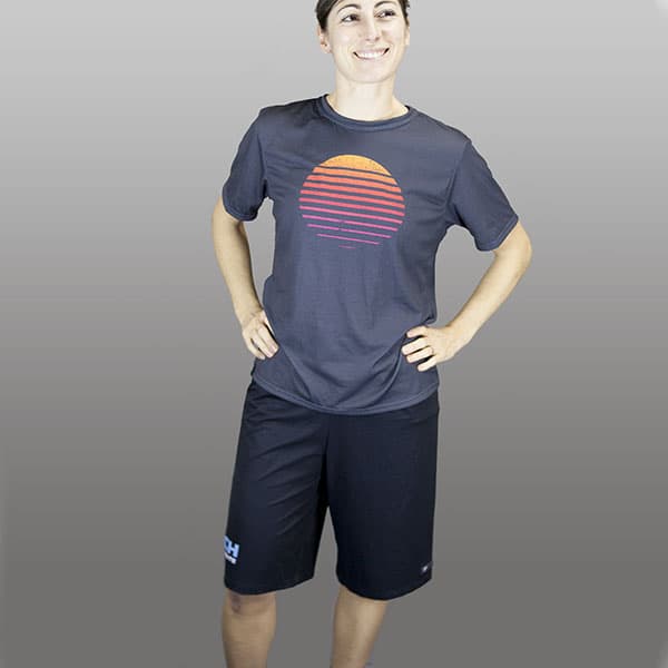 woman smiling wearing long black shorts and dark grey tshirt