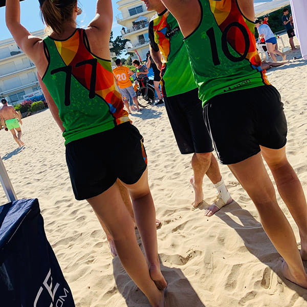 back view of women on beach wearing colorful jerseys and short black shorts