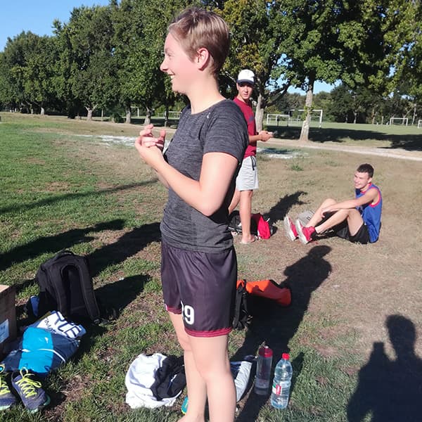 woman smiling on a sport field with black tshirt and shorts
